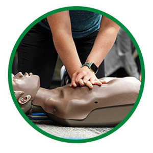A Student Practices Chest Compressions on a First Aid Mannequin