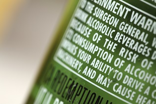 A Bottle of Alcohol with Government Warnings, Including the Impairing Effects Alcohol Can Have on Operating a Vehicle, Equipment and Machinery