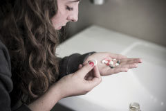 A Young Woman with Opioid Pills in Her Hand